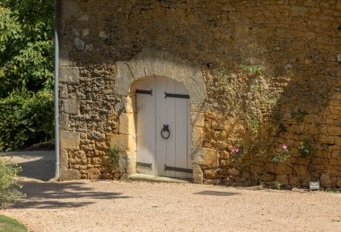 Taş çerçeveli ve askılı menteşeli klasik beyaz ahşap çift kapı.