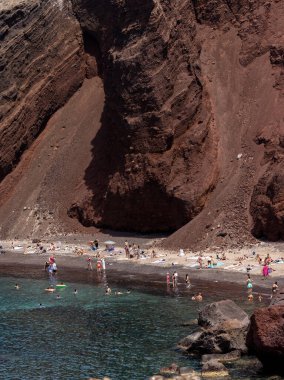 Santorini, Yunanistan - 01 Temmuz 2021: Santorini adasının güney kıyısındaki ünlü Kızıl Kumsal, Kiklad, Ege Denizi.