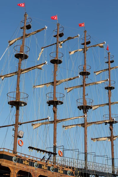 Alberi e vele di enorme barca a vela sullo sfondo del cielo blu — Foto Stock