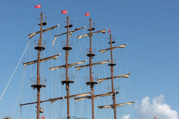 Masts and sails of huge sailing boat against the background of blue sky — Stock Photo, Image