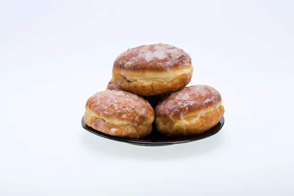 Whole donuts on the black porcelain plate — Stock Photo, Image