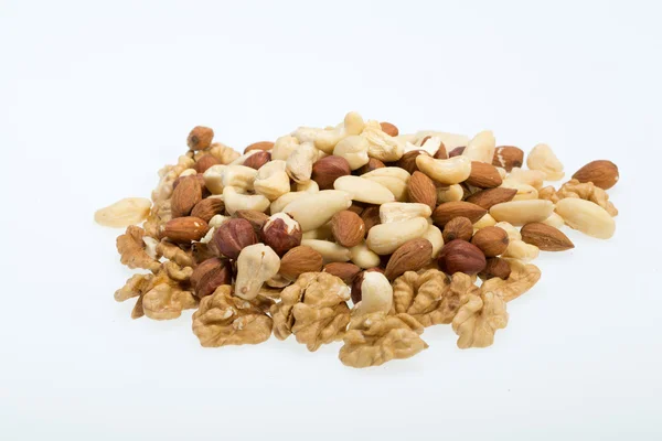 Smíšený ořechy - lískové oříšky, vlašské ořechy, Kešu ořechy, piniové oříšky izolovaných na bílém pozadí — Stock fotografie