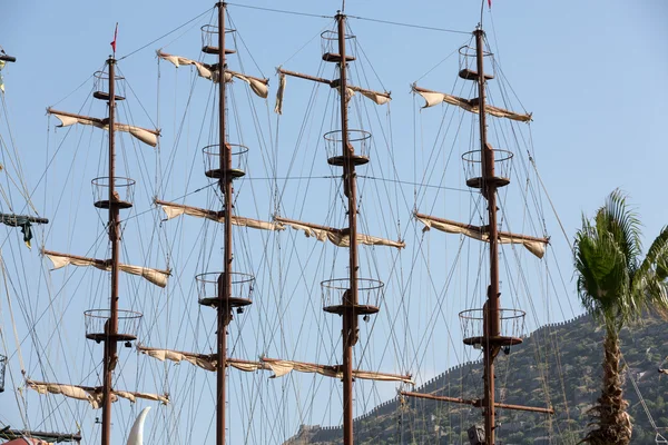 Masts and sails of huge sailing boat against the background of blue sky — Stock Photo, Image