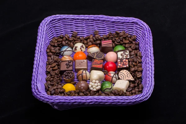 Conjunto de várias pralinas de chocolate e grãos de café em cesta de lavanda — Fotografia de Stock