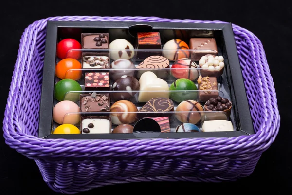 Conjunto de vários pralinos de chocolate na cesta de lavanda — Fotografia de Stock