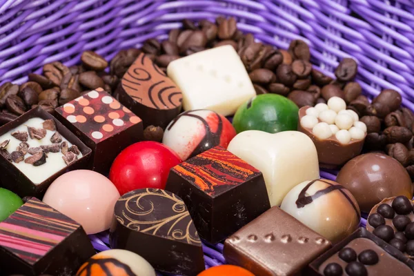 Set aus verschiedenen Schokoladenpralinen und Kaffeebohnen im Lavendelkorb — Stockfoto