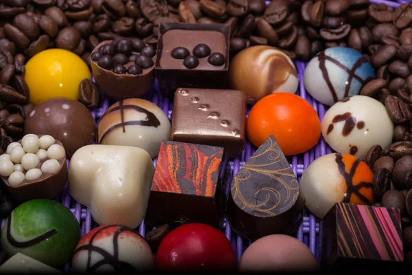 Set aus verschiedenen Schokoladenpralinen und Kaffeebohnen im Lavendelkorb — Stockfoto