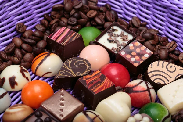 Conjunto de várias pralinas de chocolate e grãos de café em cesta de lavanda — Fotografia de Stock