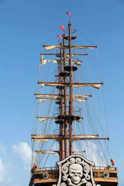 Masts and sails of huge sailing boat against the background of blue sky — Stock Photo, Image