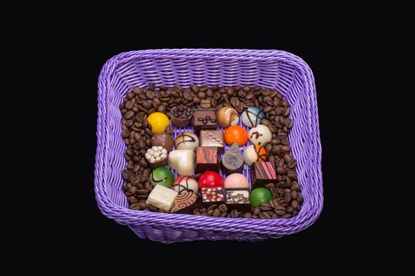 Set de varios pralinés de chocolate y granos de café en canasta de lavanda — Foto de Stock