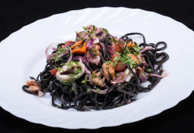Deniz ürünleri ve sebze ile siyah spagetti