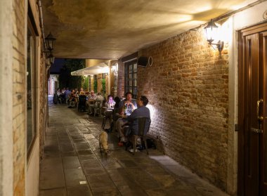 Venedik, İtalya - 4 Eylül 2022: Venedik, İtalya 'nın San Polo bölgesindeki bir açık hava restoranında turistler