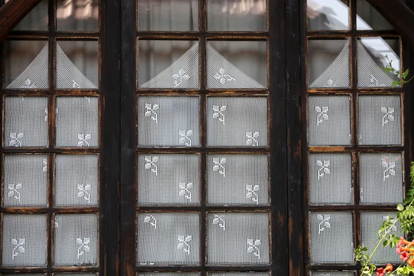 Houten gesloten venster met witte kant gordijnen, — Stockfoto