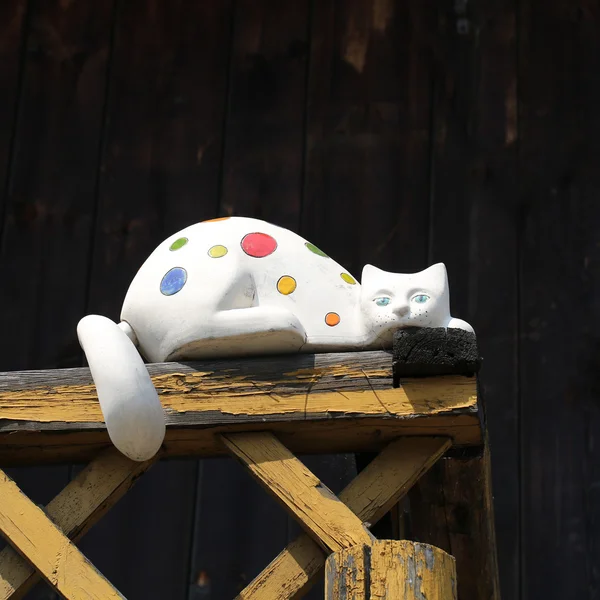 Chat en porcelaine colorée sur balcon en bois — Photo