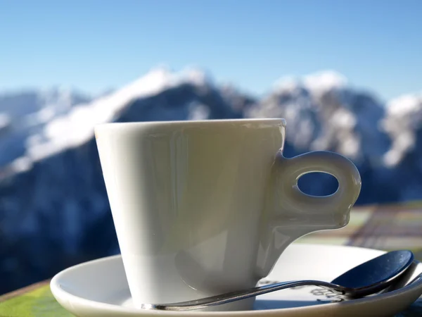 Cup of Coffee on Snow Mountains Background