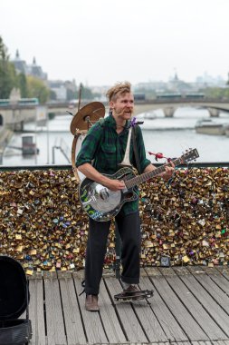 A street musician busker entertain public on Pont des Arts in Paris, France clipart