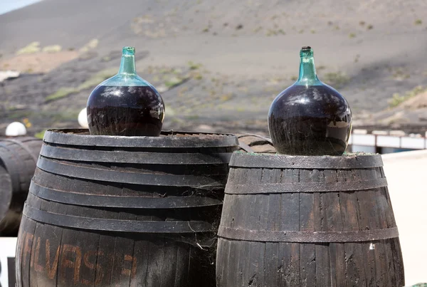 Barrels and  big bottles with grape wine - malvasia.  Lanzarote, Spain — Stock Photo, Image