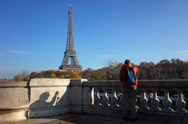 男性游客在比尔 哈基姆桥的观景台上拍摄埃菲尔铁塔的照片 人影在石墙上 秋天阳光明媚的蓝天真实瞬间未经过滤的照片 — 图库照片