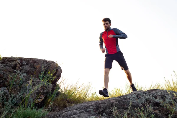 Mladý sportovec běží na Rocky Mountain Trai večer. Aktivní životní styl — Stock fotografie