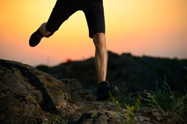 Gros plan sur les jambes d'un sportif qui court sur le sentier des Rocheuses la nuit. Mode de vie actif — Photo
