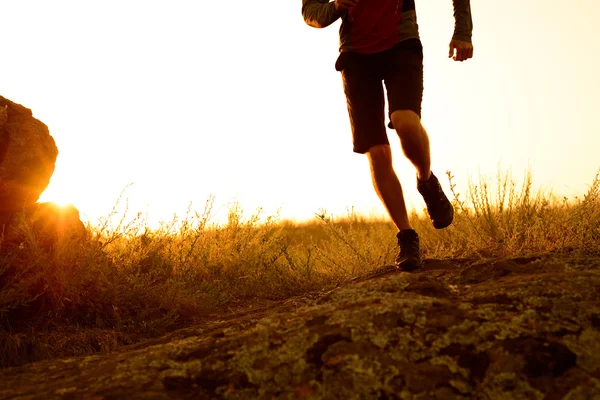 Gros plan sur les jambes d'un sportif qui court sur le sentier des Rocheuses au coucher du soleil. Mode de vie actif — Photo