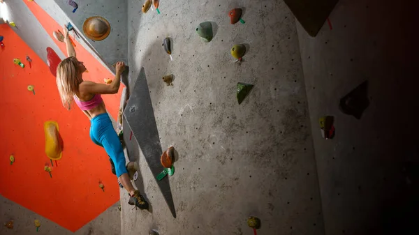 Mujer hermosa escalador Bouldering en el gimnasio de escalada. Deporte extremo y concepto de escalada interior —  Fotos de Stock