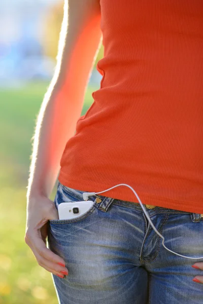 Smartphone with Headphones in Pocket of Woman Jeans — Stock Photo, Image