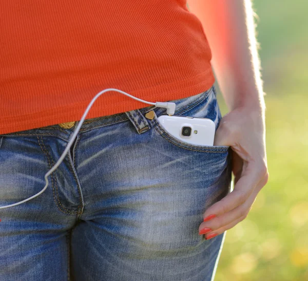 Smartphone con Auriculares en Pocket of Woman Jeans — Foto de Stock