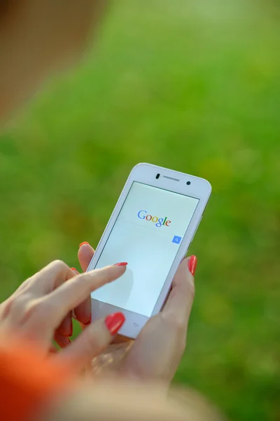 DNIPROPETROVSK, UKRAINE - 18 SEPTEMBRE 2014 : Une jeune femme utilise Google Web Search sur son téléphone intelligent . — Photo