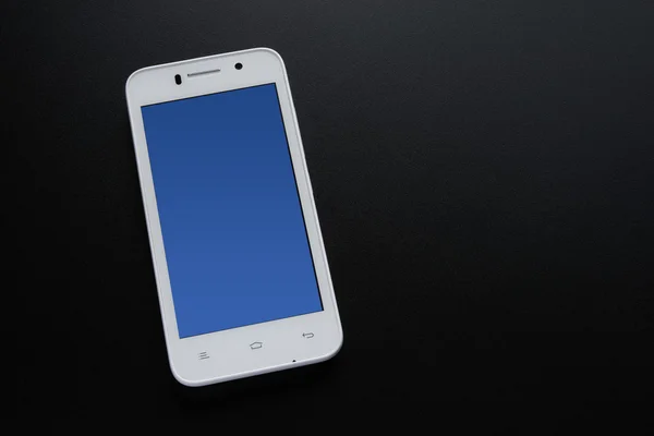 White Smart Phone With Blue Screen on the Black Table — Stock Photo, Image