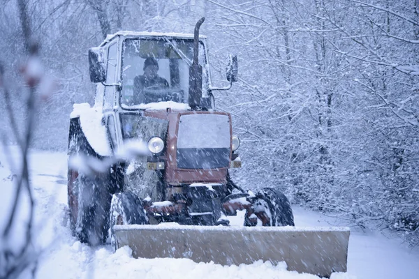 Traktor, vyčištění od sněhu v Heawy sněžení — Stock fotografie