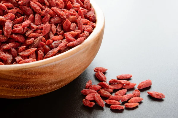Wooden Bowl Full of Dried Goji Berries on the Dark Table — Stock Photo, Image