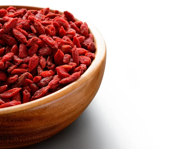 Ciotola di legno piena di bacche di Goji essiccate sul tavolo bianco — Foto Stock