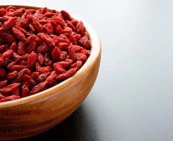 Wooden Bowl Full of Dried Goji Berries on the Dark Table — Stock Photo, Image