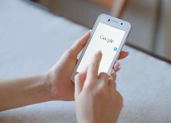 ЗАПОРИЖЬЯ, УКРАИНА - 21 НОЯБРЯ 2014 г.: Девушка, использующая Google Web Search на своем смартфоне . — стоковое фото