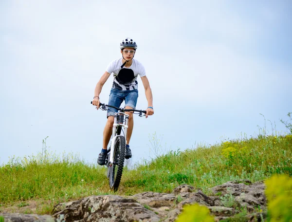 Ciclista montando a bicicleta na bela trilha de montanha de primavera — Fotografia de Stock