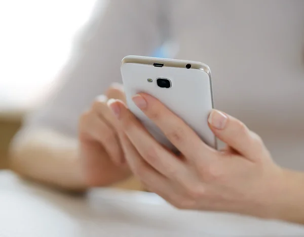 Mujer usando su teléfono móvil inteligente en casa — Foto de Stock