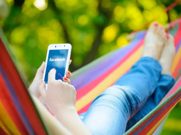 ZAPORIZHZHYA, UKRAINE - SEPTEMBER 20, 2014: Young Woman Using Facebook Application on her Smart Phone. — Stock Photo, Image