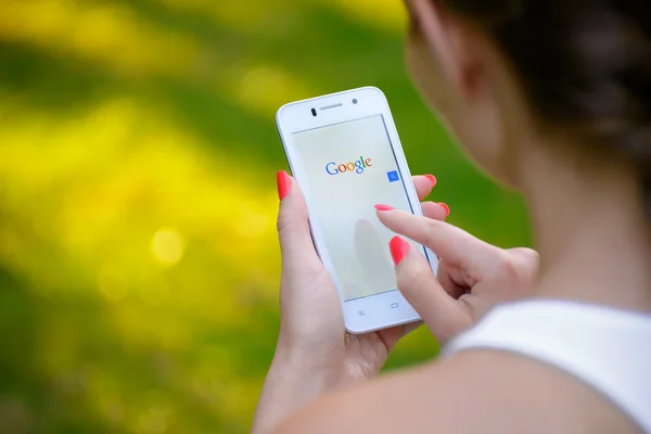 ZAPORIZHZHYA, UKRAINE - SEPTEMBER 20, 2014: Young Woman Using Google Web Search on her Smart Phone. — Stockfoto