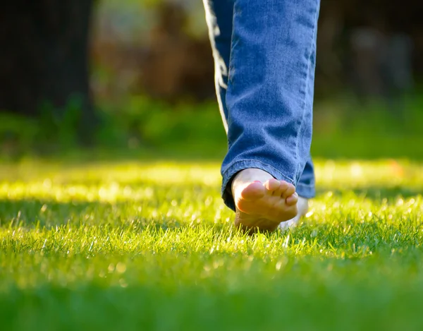 Mujer piernas descalzas en la hierba verde en el jardín — Foto de Stock