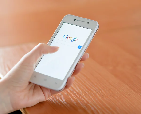 ЗАПОРИЖЬЯ, УКРАИНА - 23 ЯНВАРЯ 2015: Молодая женщина использует Google Web Search на своем смартфоне . — стоковое фото