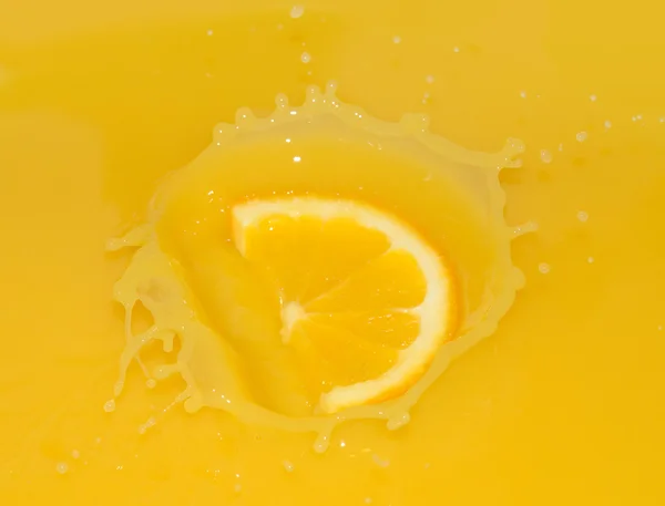 Ripe Orange Slice Falling into Juice — Stock Fotó