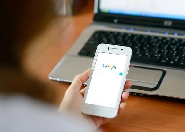 ZAPORIZHZHYA, UCRANIA - ENERO 23, 2015: Mujer joven usando Google Web Search en su teléfono inteligente . — Foto de Stock