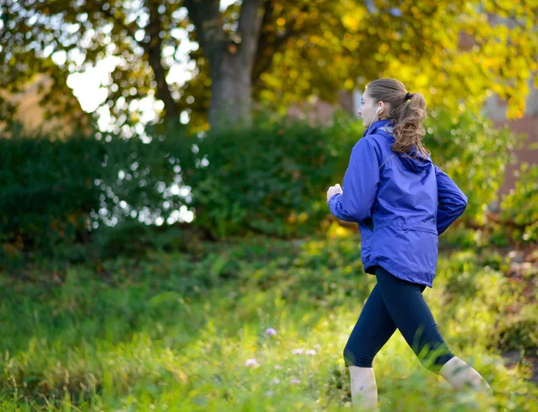 Jeune belle femme courant dans le parc — Photo