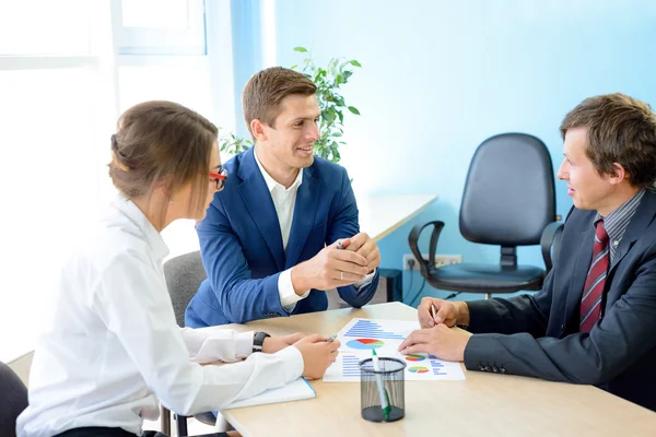 Gli uomini d'affari che analizzano i risultati finanziari sui grafici intorno alla tabella nell'ufficio moderno. Concetto di lavoro di squadra — Foto Stock