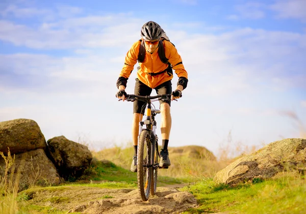 Ciclista montando la bicicleta en el sendero de montaña de la mañana —  Fotos de Stock
