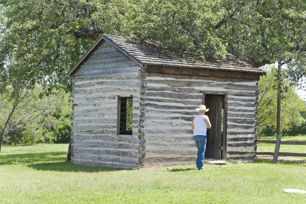 Cowboy Walking Toward a Log Cabin — Stock Photo, Image