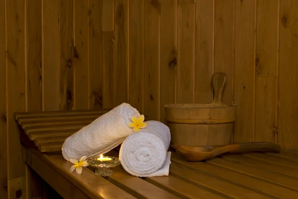 Banco de sauna com toalhas brancas e balde — Fotografia de Stock