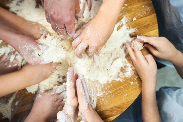 Una vista dall'alto di insegnare ai bambini le arti culinarie. Mani di bambini e maestri. — Foto Stock