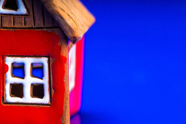 Miniaturní červený dům na tmavém pozadí. Koncept koupě nemovitosti. — Stock fotografie